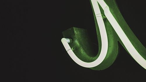a green and white illuminated sign on a black background